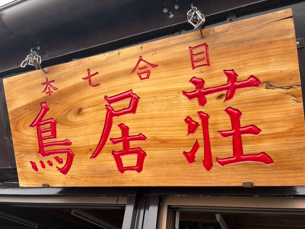 「本七合目 鳥居荘」と朱色で彫られた木の看板。この日のゴール